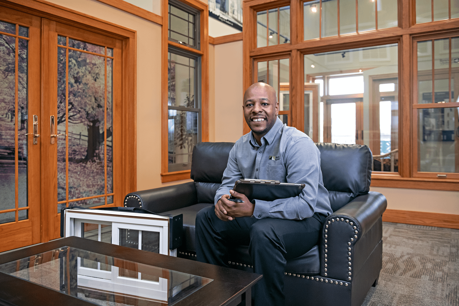 A Renewal by Andersen design consultant sitting in a couch at one of renewal by andersen's showrooms