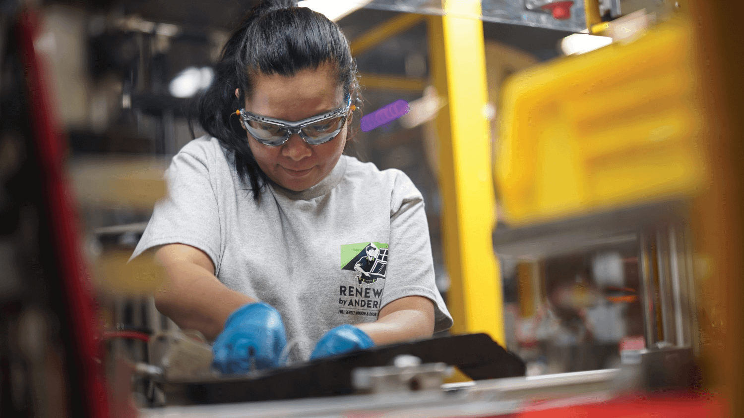 A Renewal by Andersen installer crafting a custom window in the warehouse