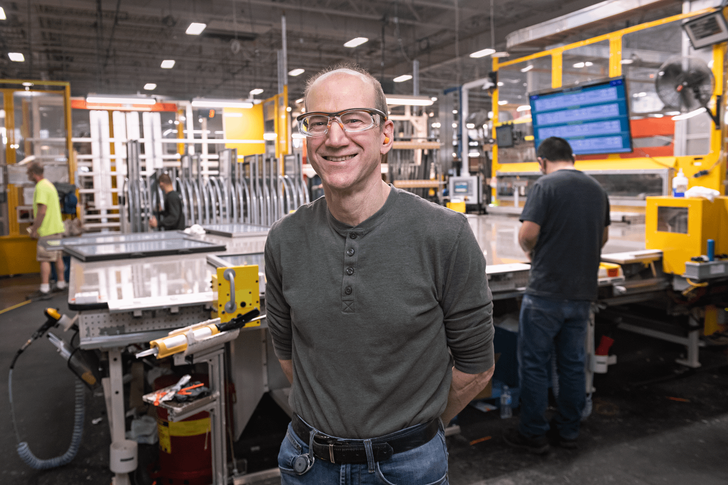 A Renewal by Andersen production association standing infront of a work station in the factory