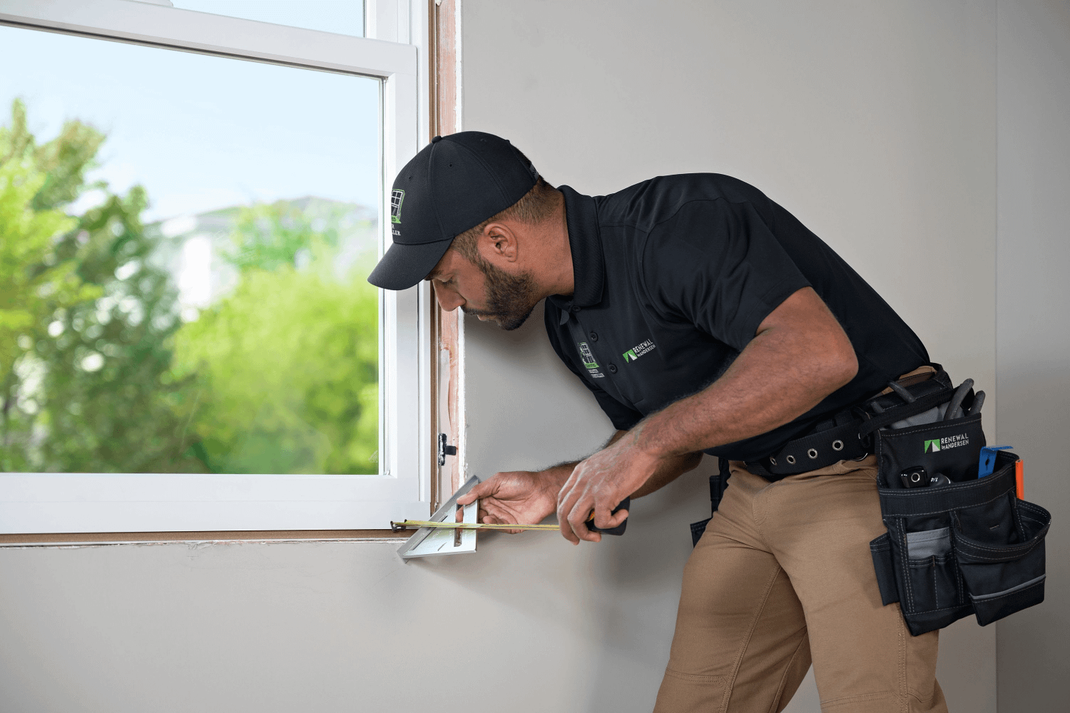Renewal by Andersen installer measuring windows for homeowners
