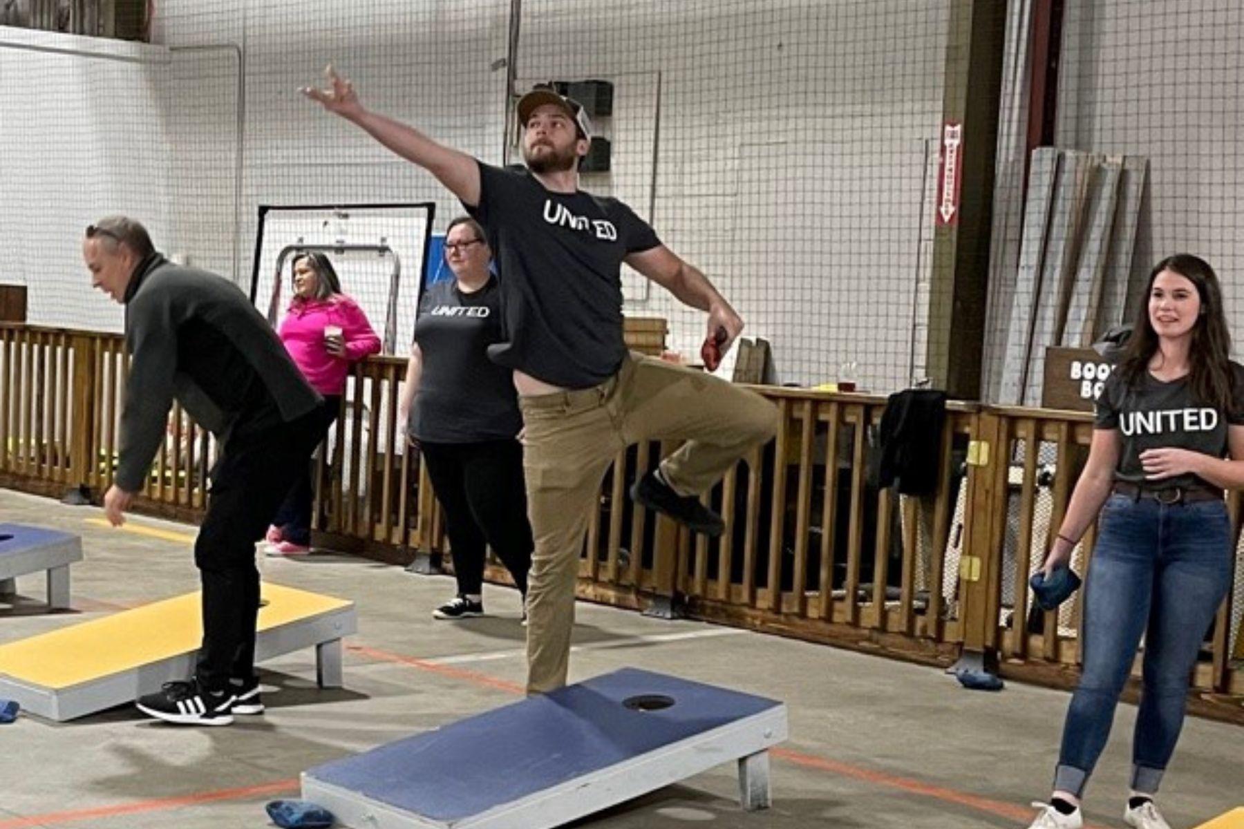Group of RbA employees playing corn hole toss. 