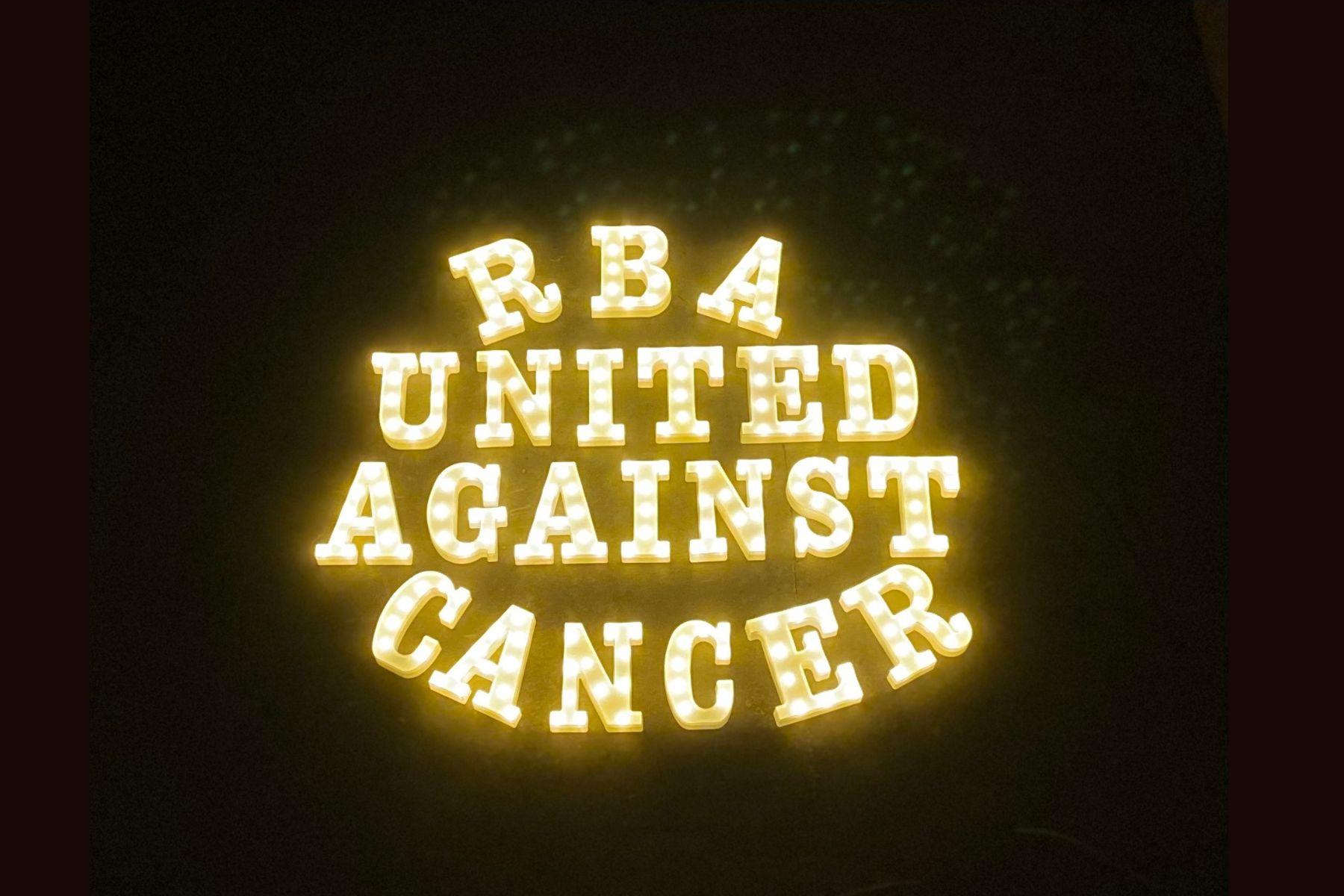 Light up marquee sign that reads "RbA United Against Cancer"