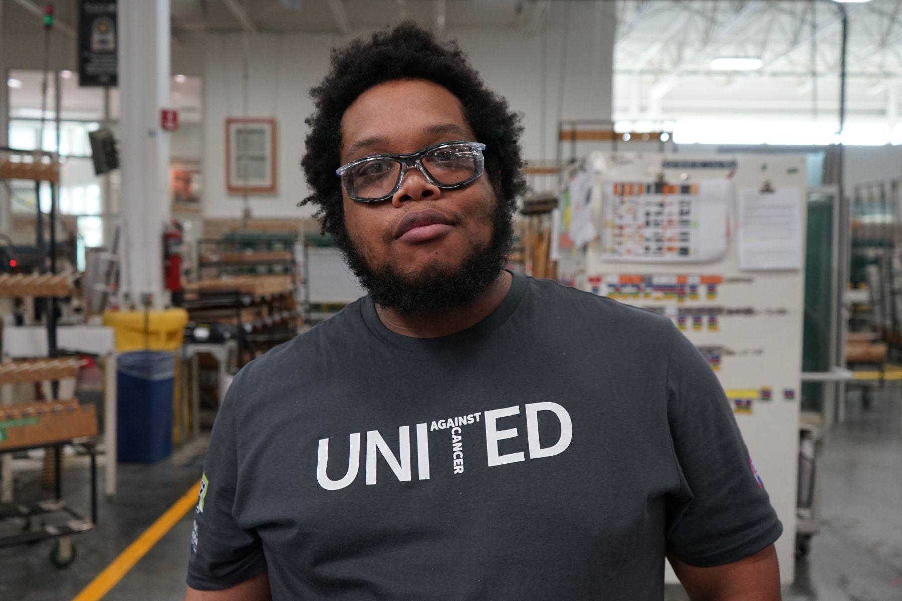 Portrait of RbA manufacturing employee wearing a United Against Cancer t-shirt.