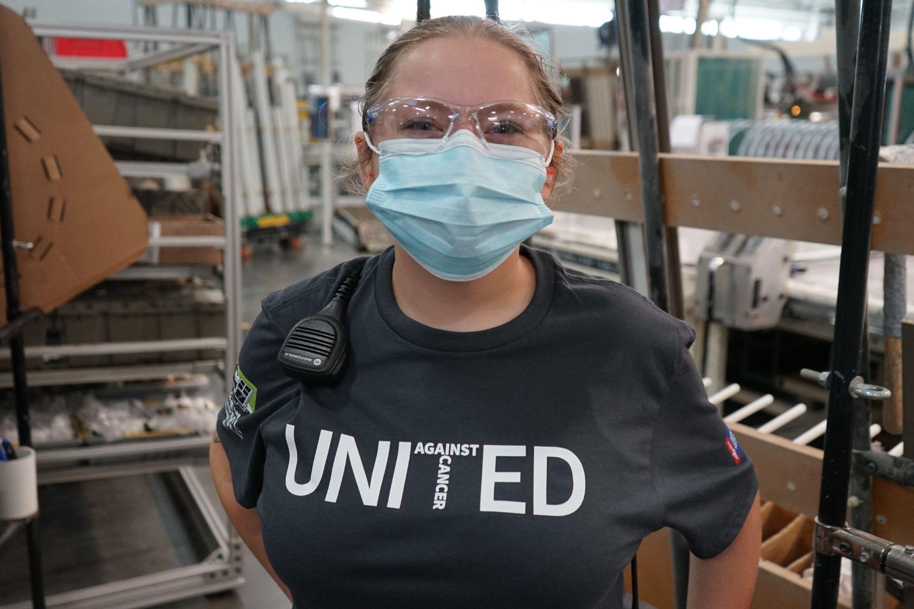 Portrait of RbA manufacturing employee wearing a mask and a United Against Cancer t-shirt.