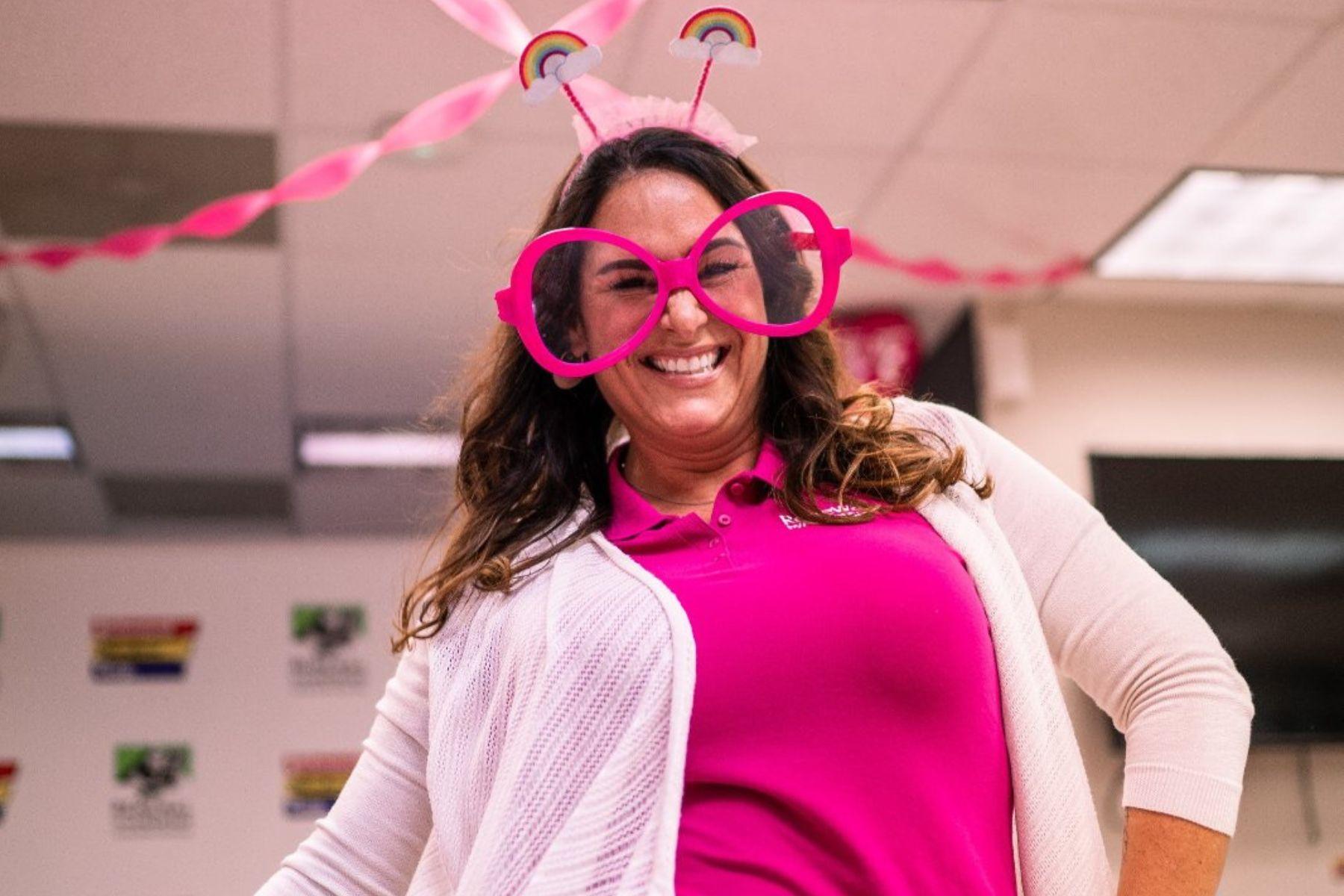 Woman wearing hot pink glasses and headband with rainbow antennas for ACS event.
