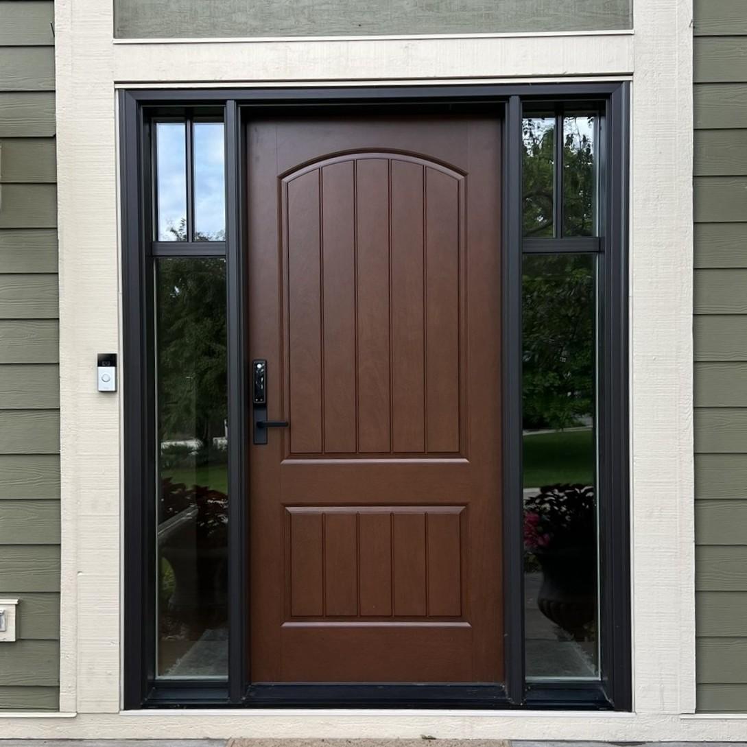 An Ensemble entry door with dual sidelights. The door has a black frame and full sidelights. The finish is mahogony wood.