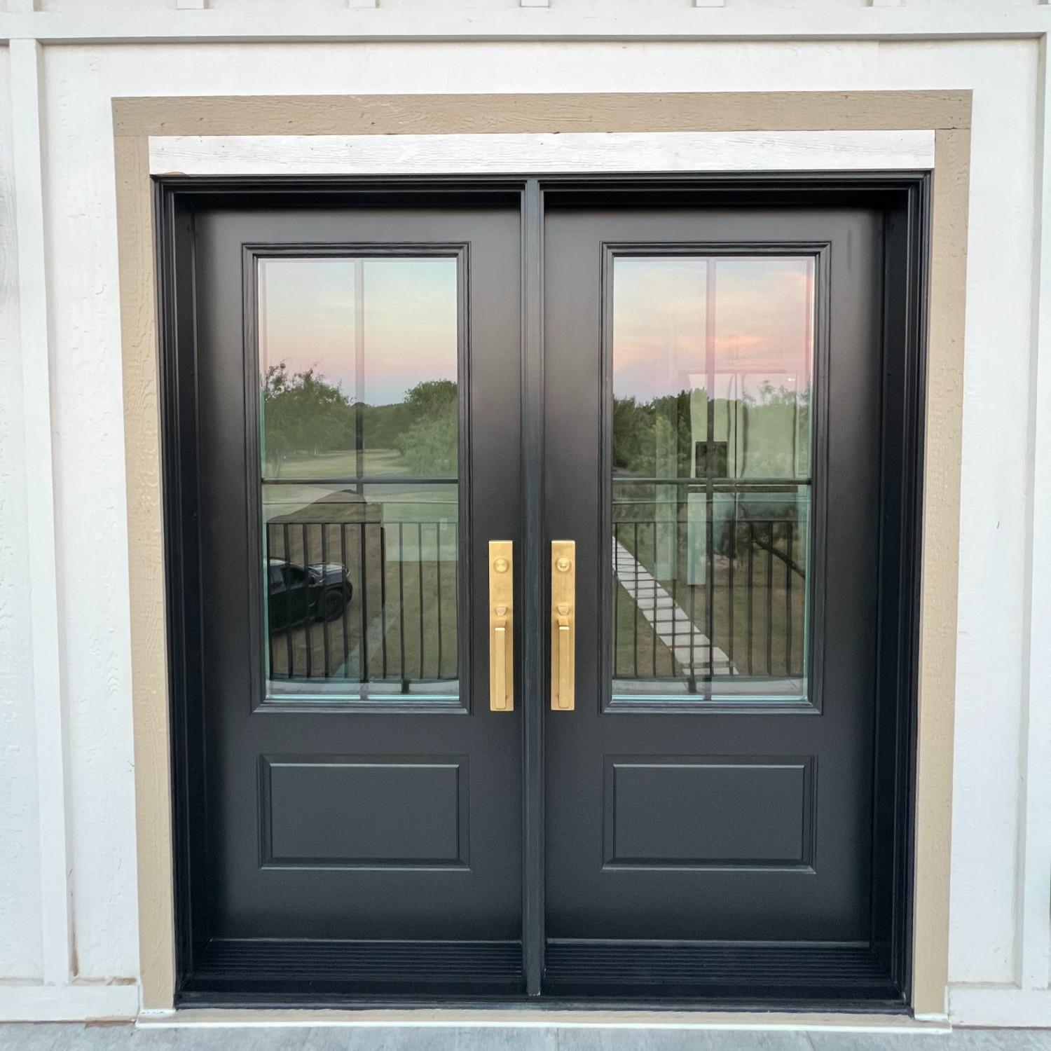 An ensemble entry double door in black with gold hardware.