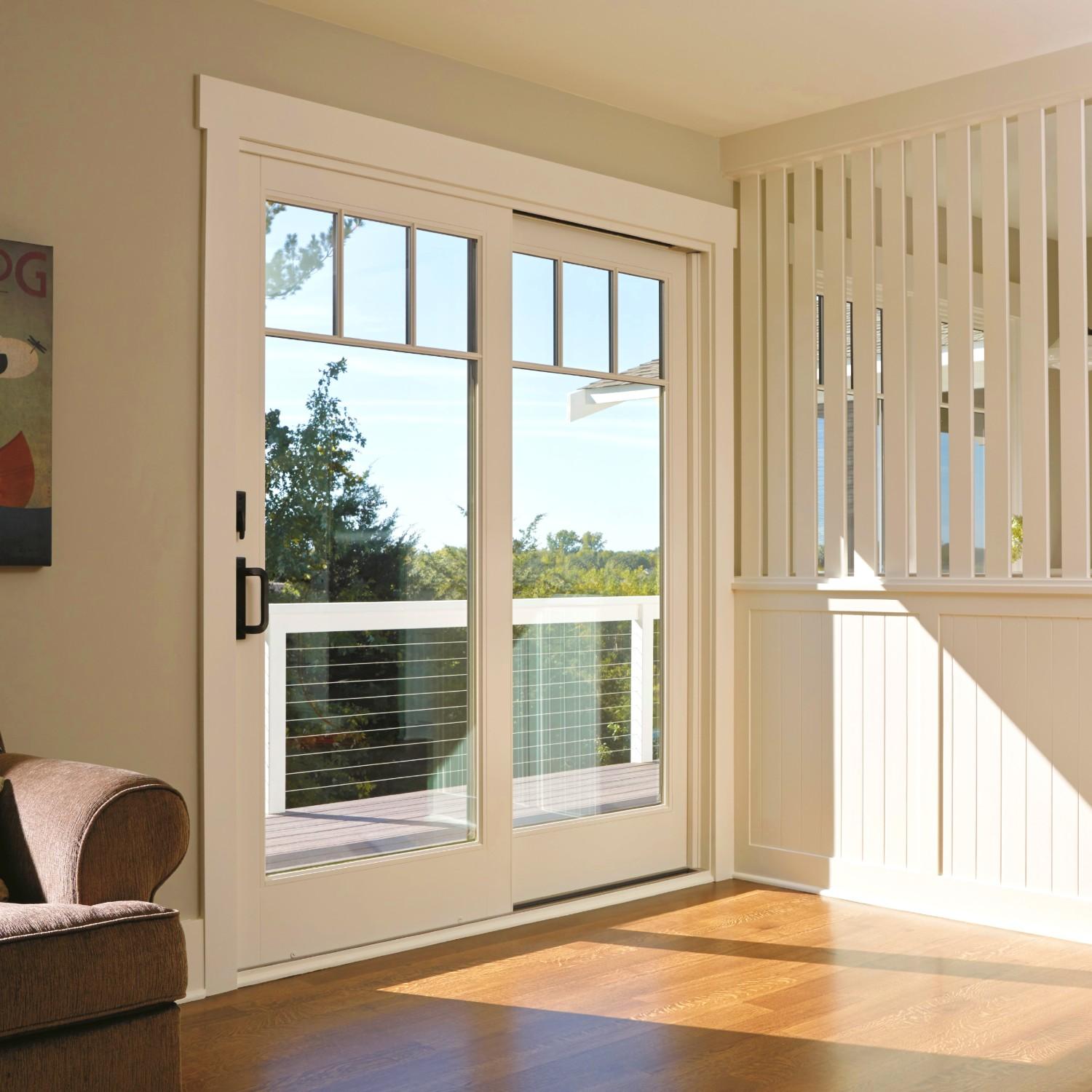 An a-series traditional sliding door in white with craftsman grilles.