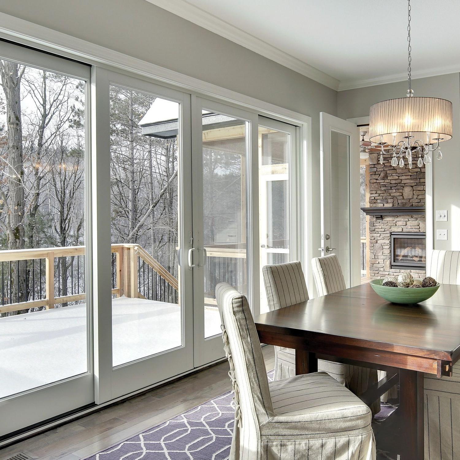 Traditional-style sliding glass doors in a kitchen. The doors are white a-series. The middle two slide open.