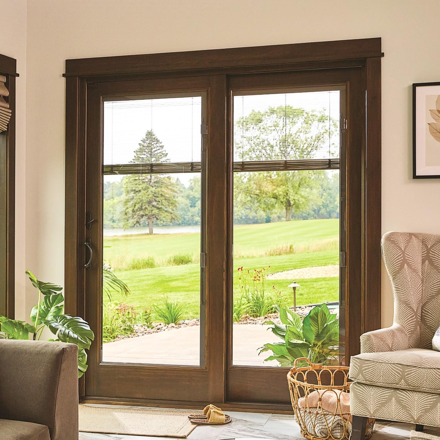 A-series traditional style sliding glass patio doors. These have a dark wood stain and blinds between the glass. There is a view of a gold course.