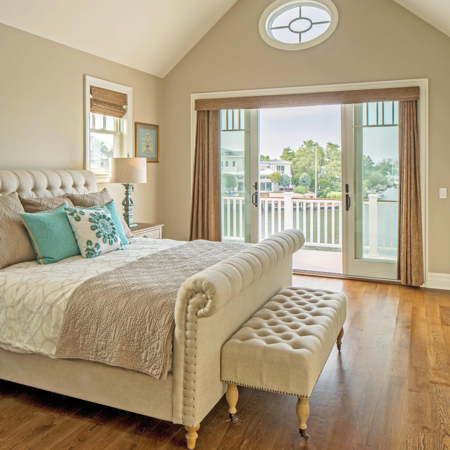 A bedroom with a white sliding door. The room looks out to a harbor.