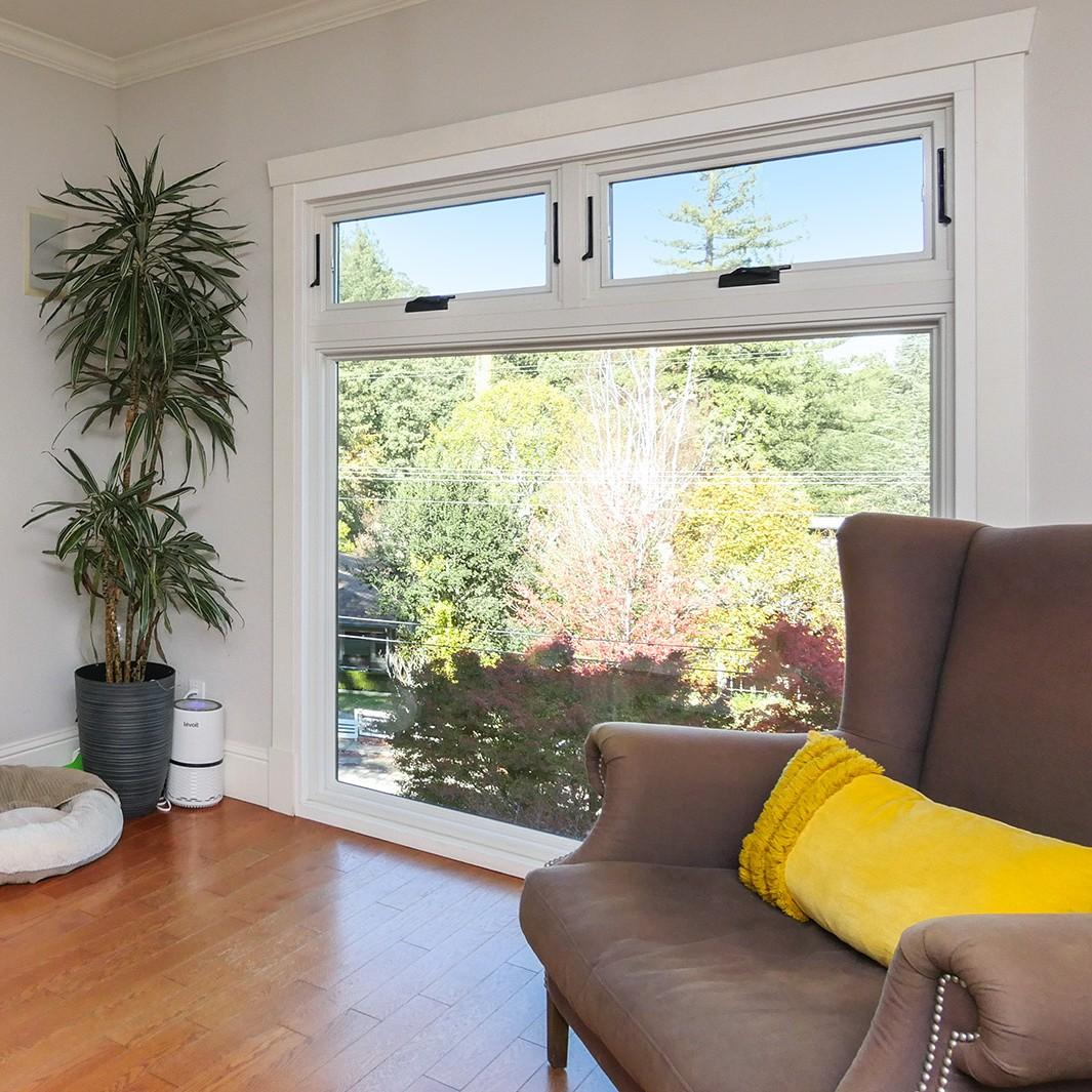 Two awning windows used as operable transoms above a large picture window.