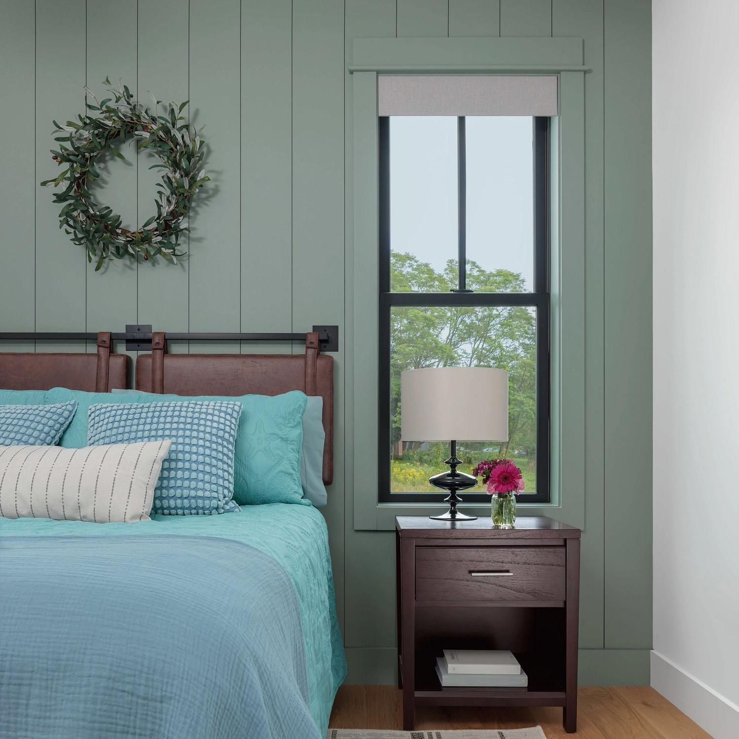 A double hung window with farmhouse grilles in a bedroom