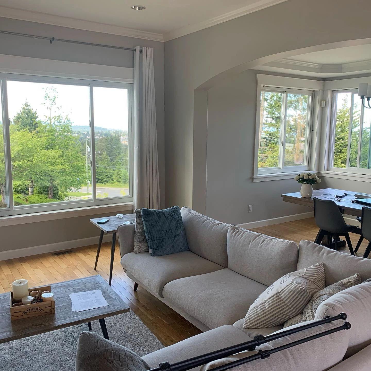 Living and dining rooms with a bank of gliding windows. The windows are white.