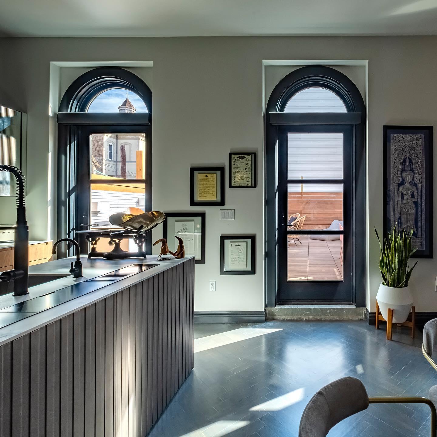 Tall black-framed windows with a circle top.