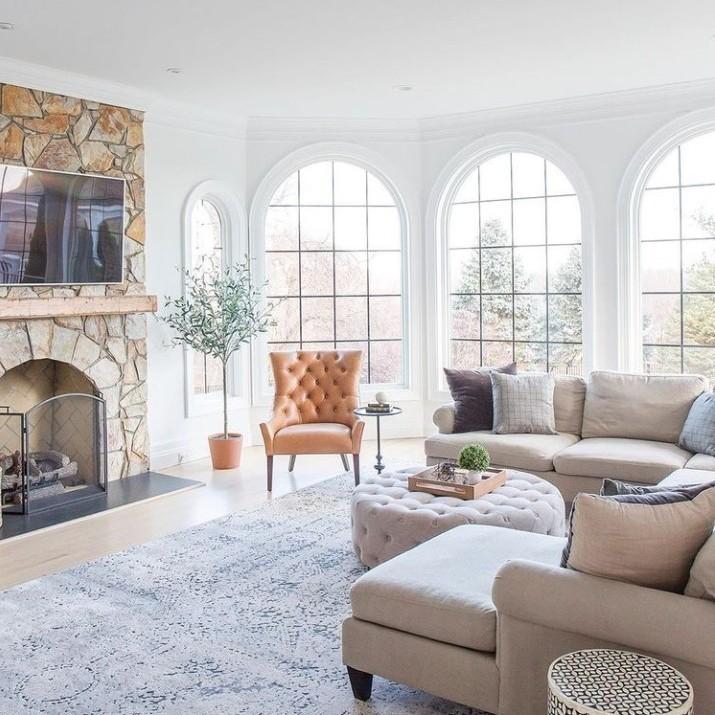 A trio of springline windows with black grilles in a living room.