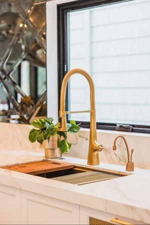 Breegan Jane's kitchen sink. It is gold with a marble counter.