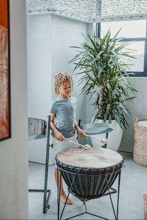 One of Breegan Jane's sons plays a drum in the playroom.